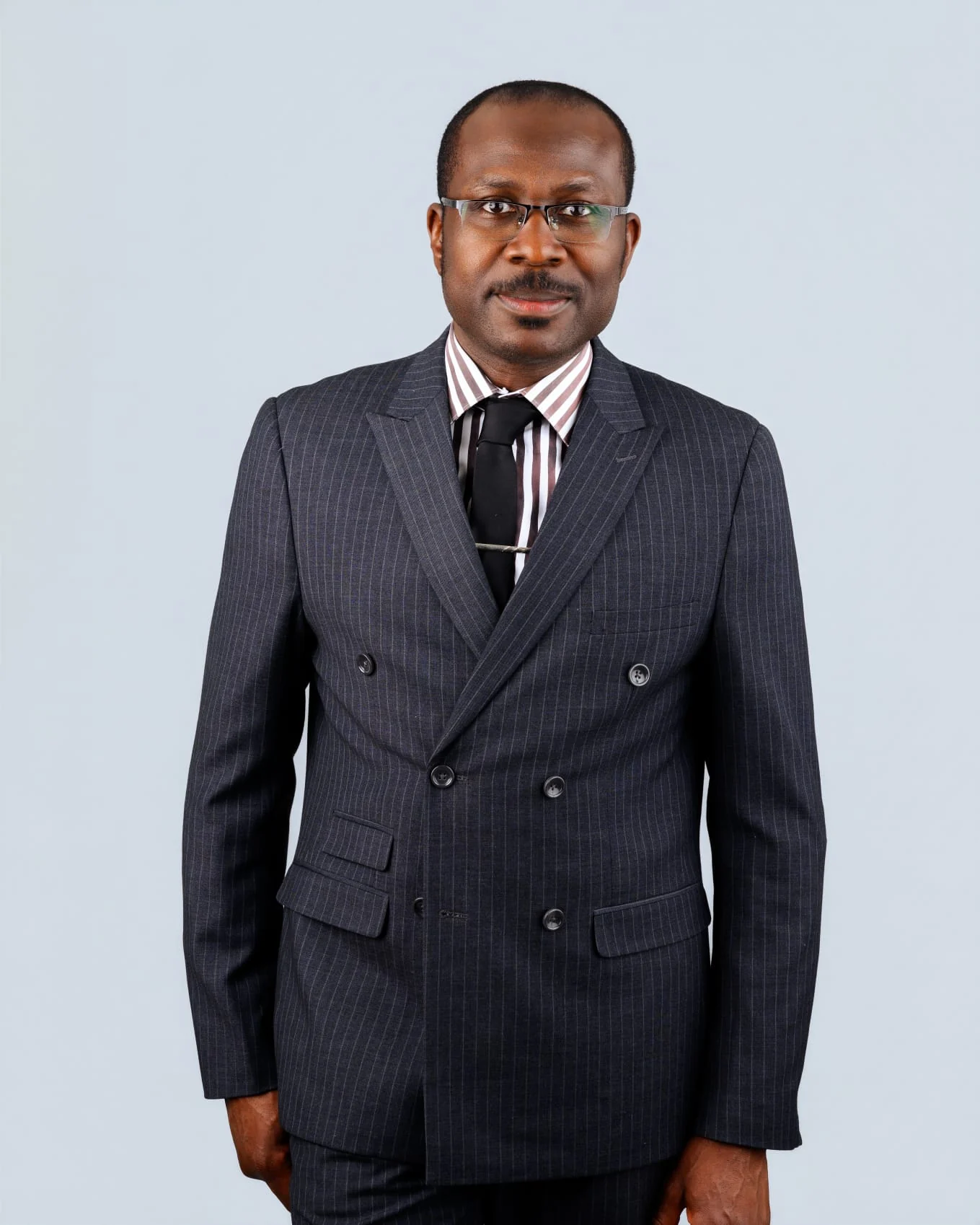 Felix Nzemeka debout en costume foncé